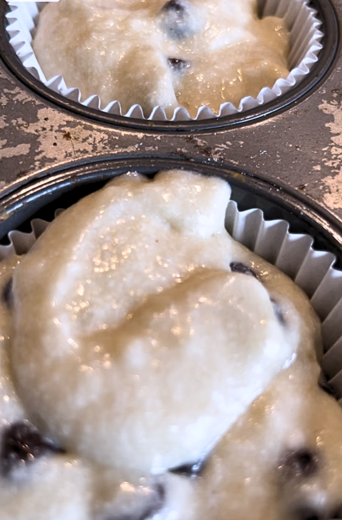 Wholesome Banana Chocolate Chip Cake batter in cupcake lines in a muffin tin.