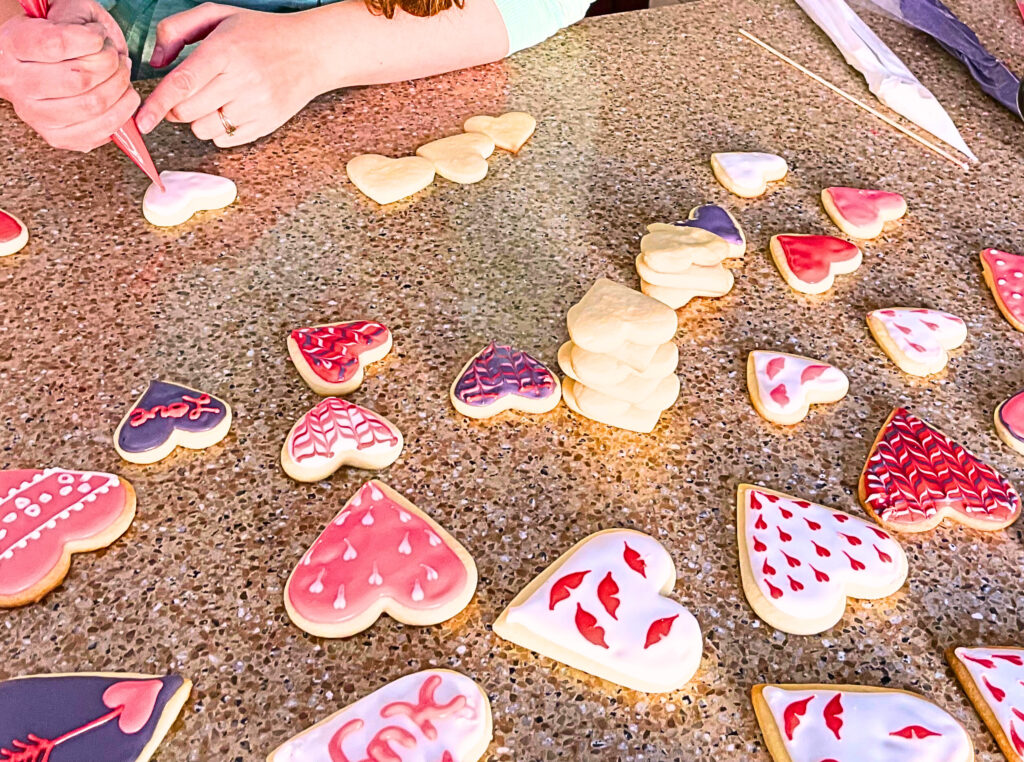 Woman decorating Valentine's day sugar cookies.