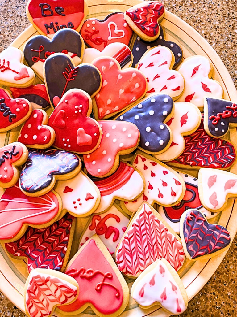 A large plater of custom decorated Valentine's day sugar cookies.