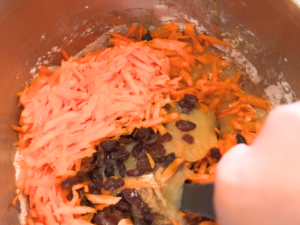 A woman mixing a carrot muffin batter.