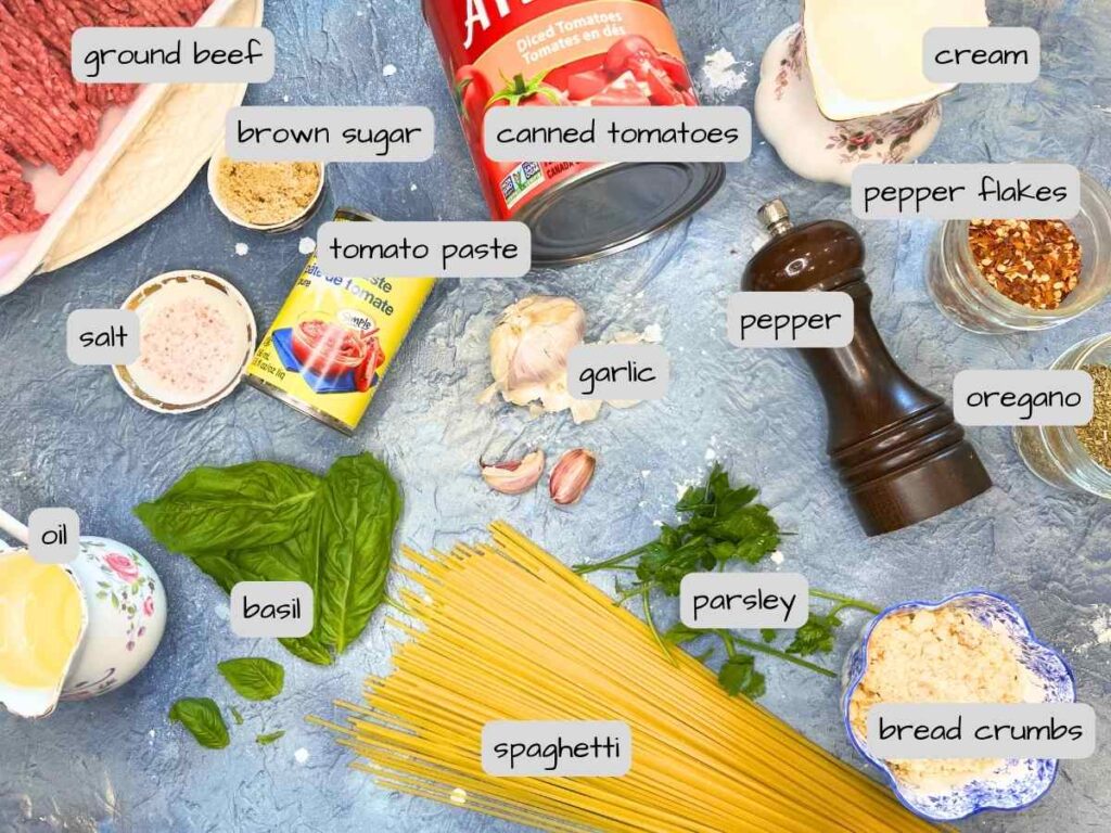 Ingredients on a blue table for spaghetti and meatballs.