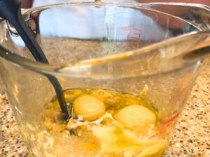 Eggs in a large glass measuring cup.