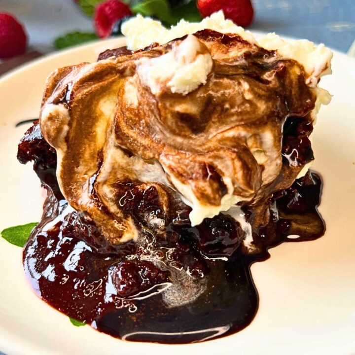 A cake with chocolate sauce and whipped cream on top.