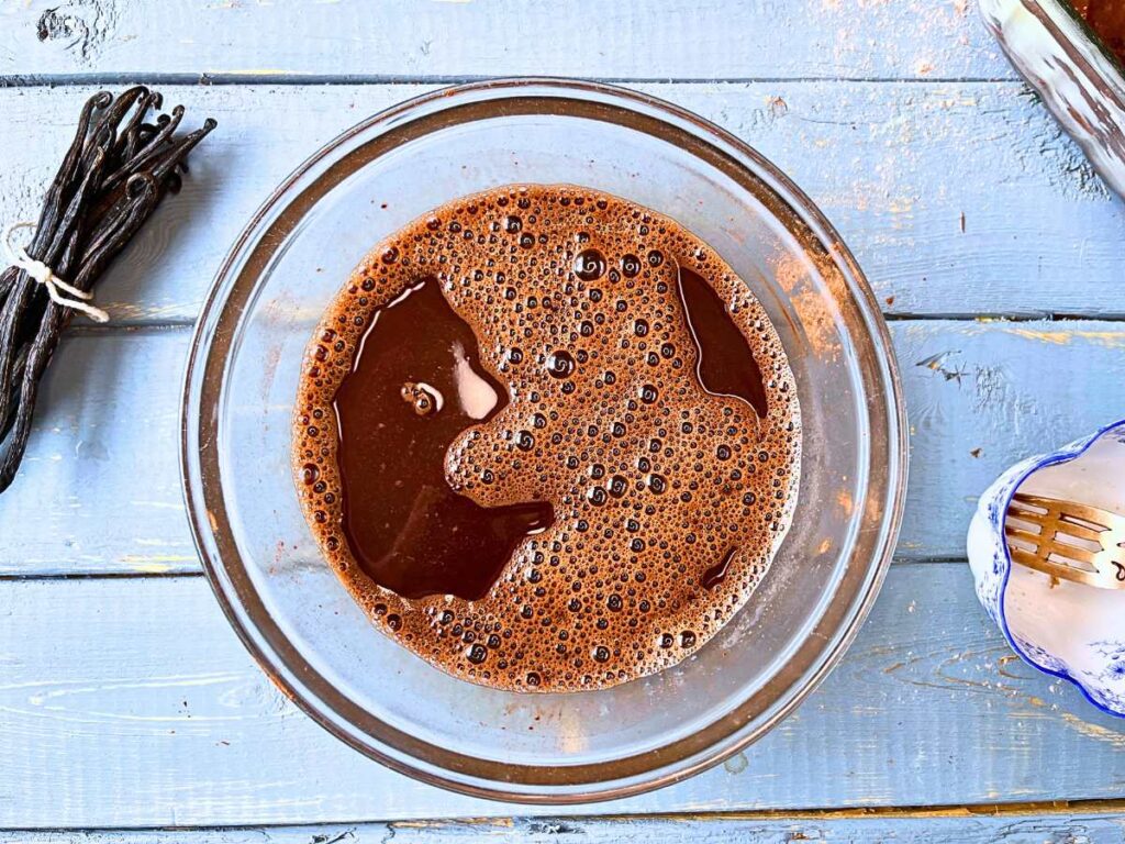 A chocolate liquid sauce in a glass bowl.