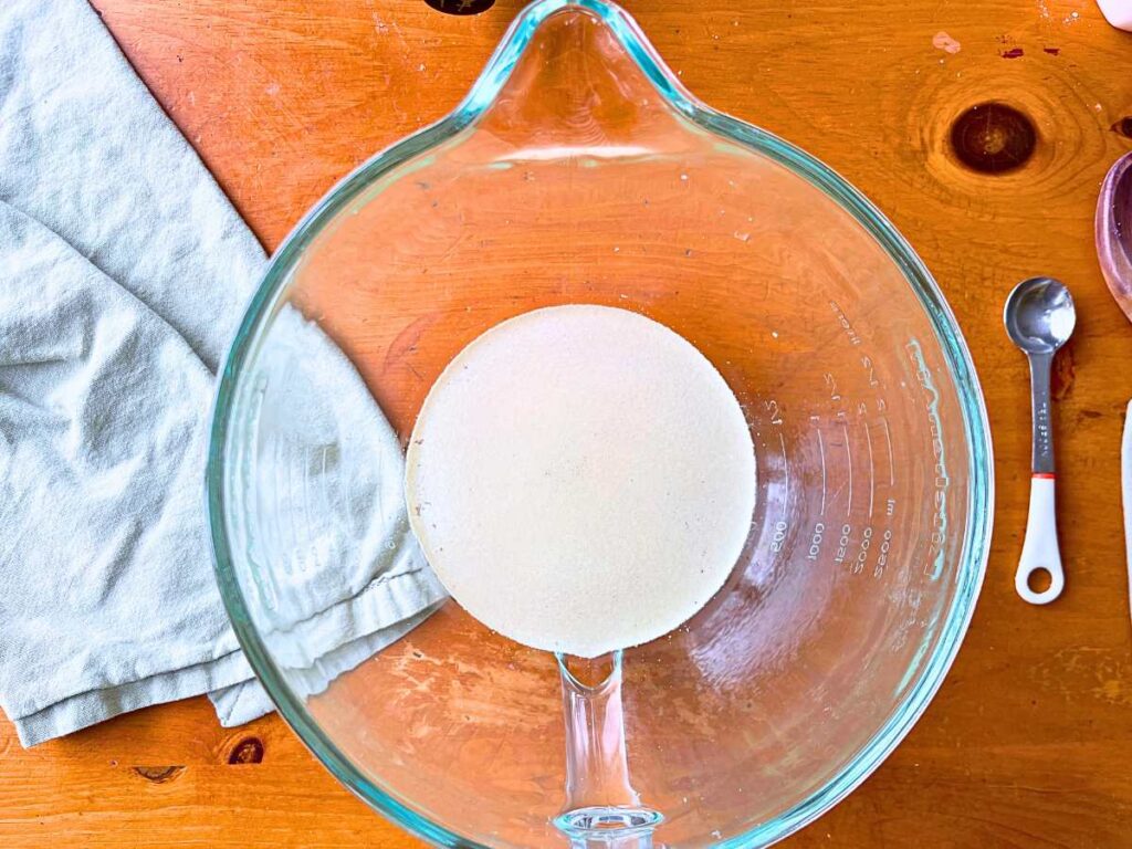 A glass bowl with water and yeast.