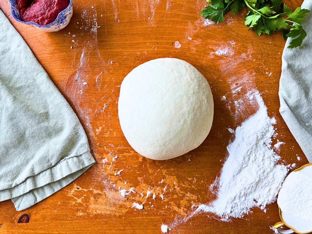 Pizza dough on a wooden table.