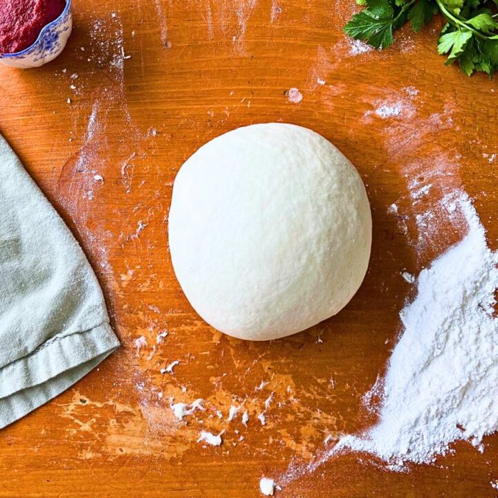 Pizza dough on a wooden table.