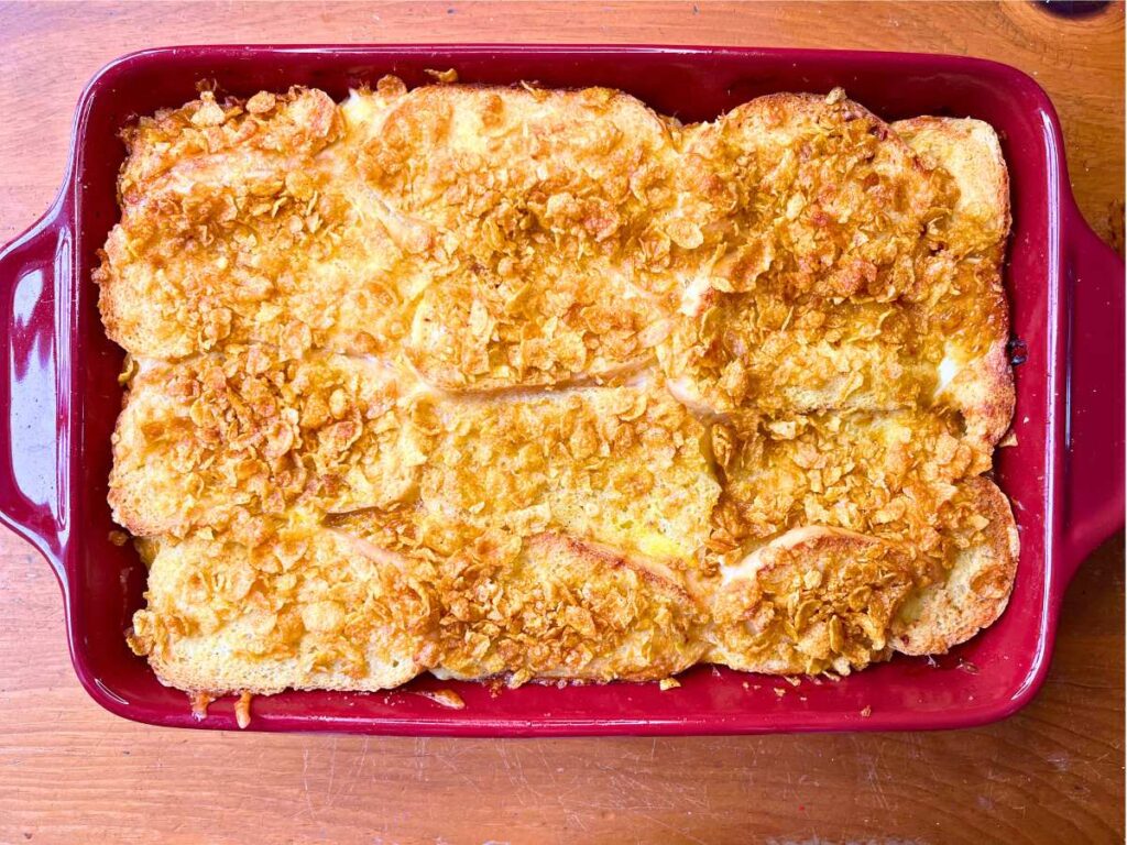 A baked breakfast strata in a red casserole dish.