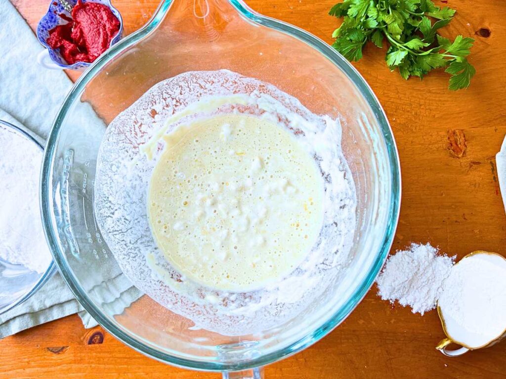 A glass bowl with batter inside.