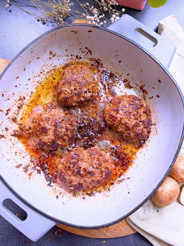 Cooked salisbury steaks in a Dutch oven.