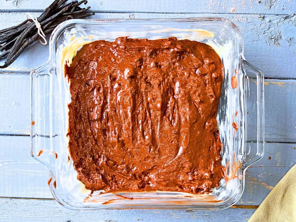 Chocolate cake batter in a square glass casserole dish.