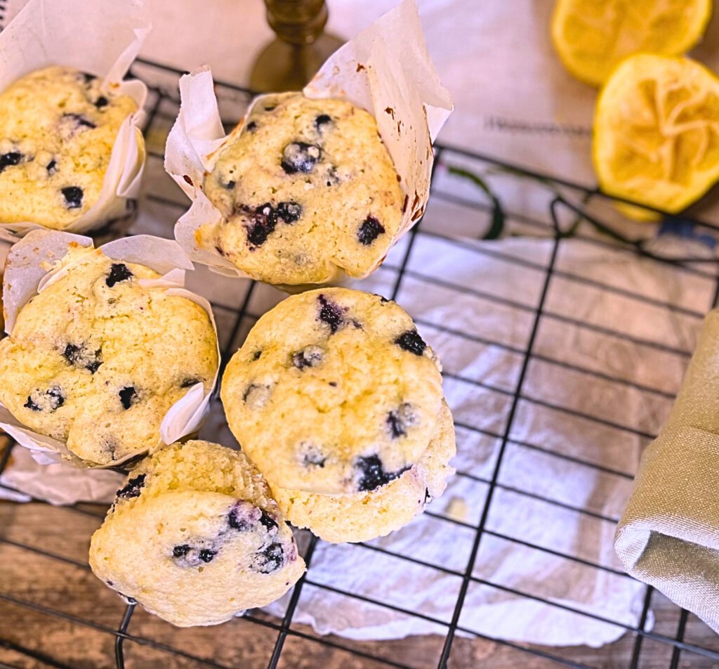 A batch of lemon blueberry muffins sitting on a cooling rack.