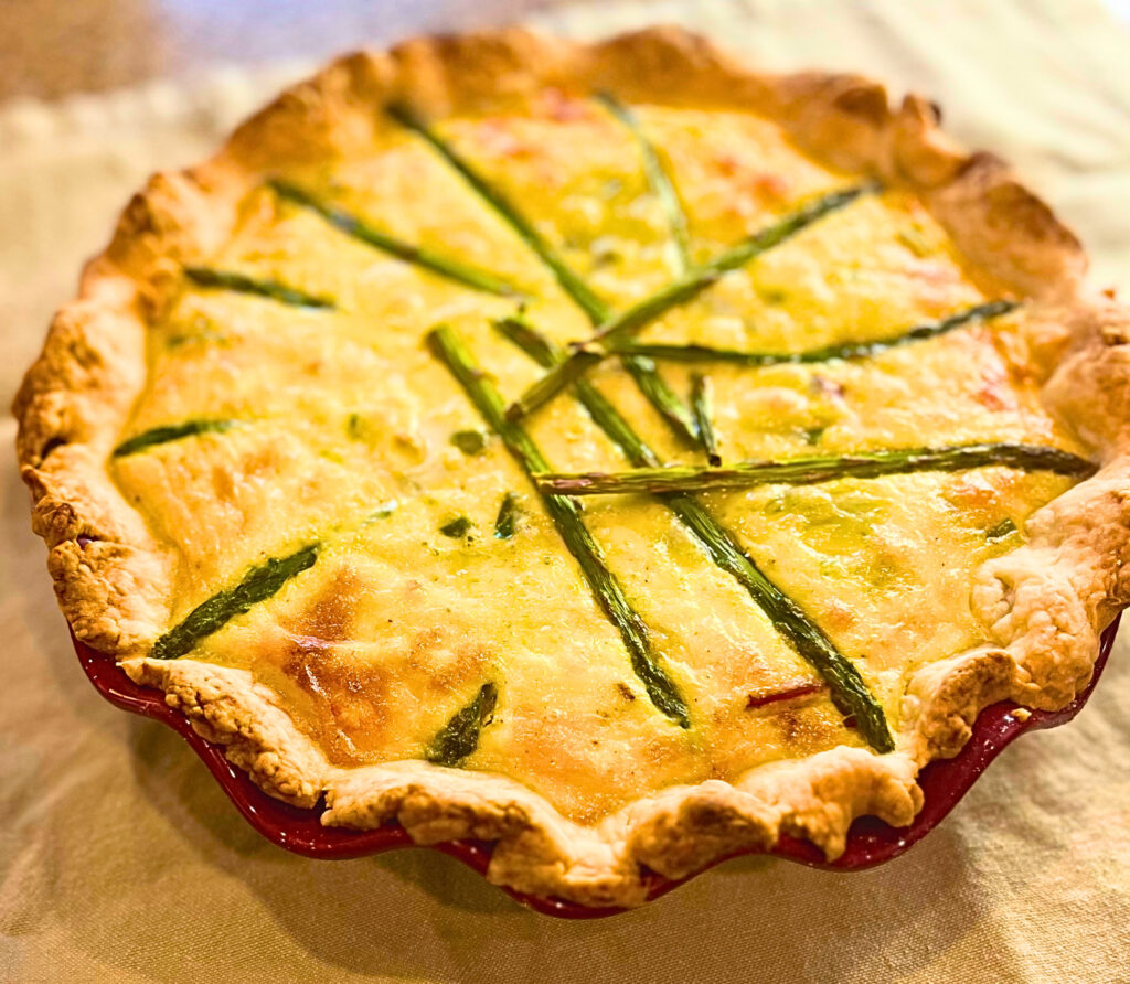 An Asparagus and Swiss Cheese Quiche on a linen napkin.