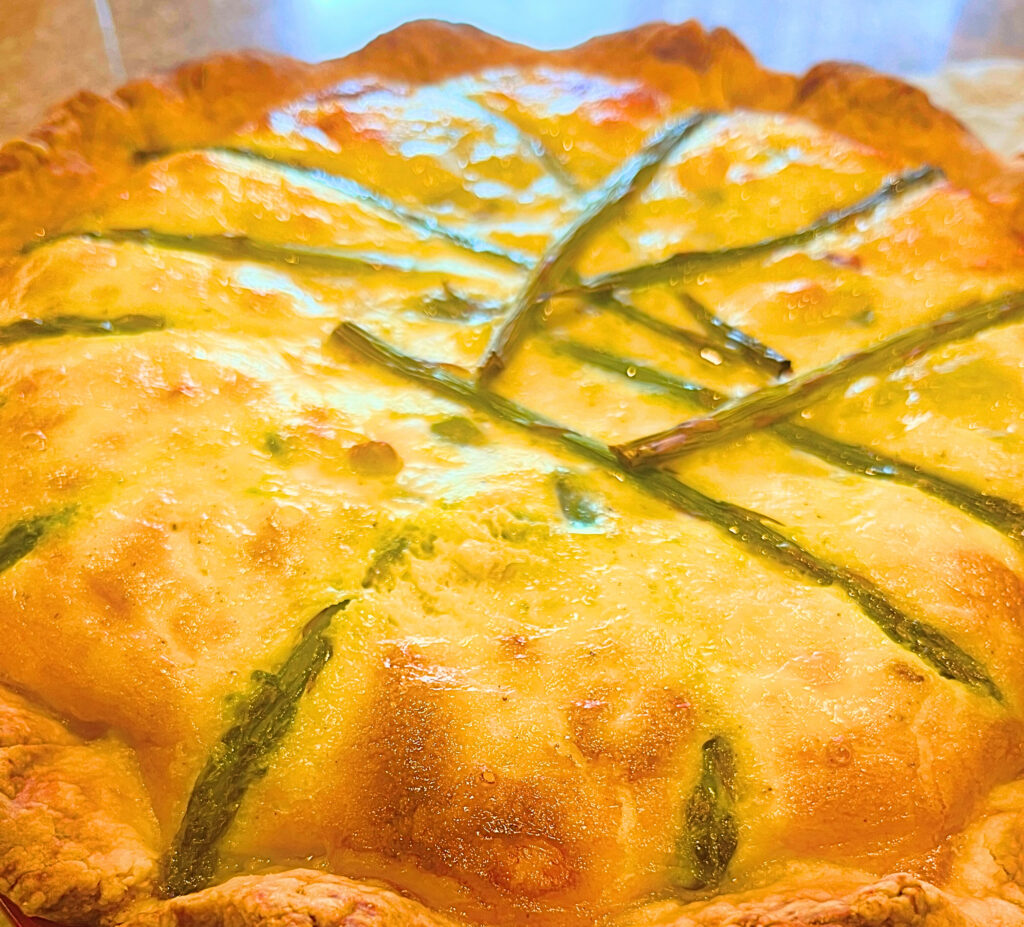 Close up of an asparagus and Swiss cheese quiche.