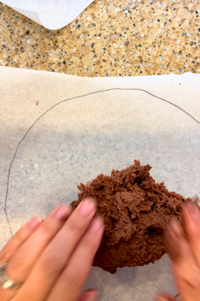 Pressing the cake batter into shape for a chocolate caramel torte