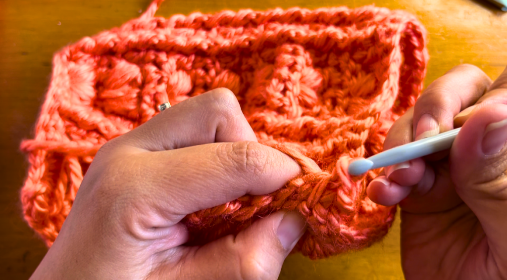 orange crochet fabric being stitched with a slip stitch