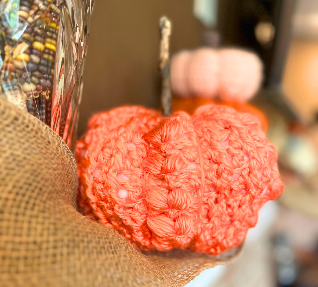 Orange crochet pumpkin on top of burlap