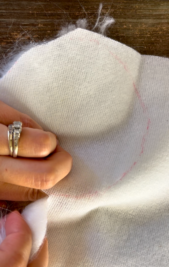 traced red circle on the back of white faux fur fabric
