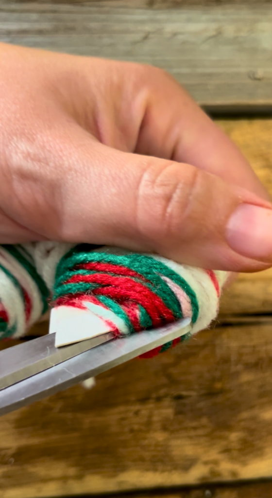 Cutting red, white, and green yarn.