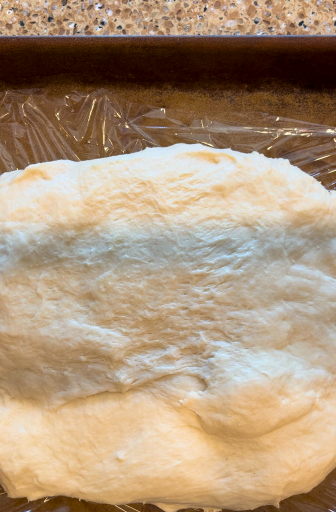 spreading dough onto a pan