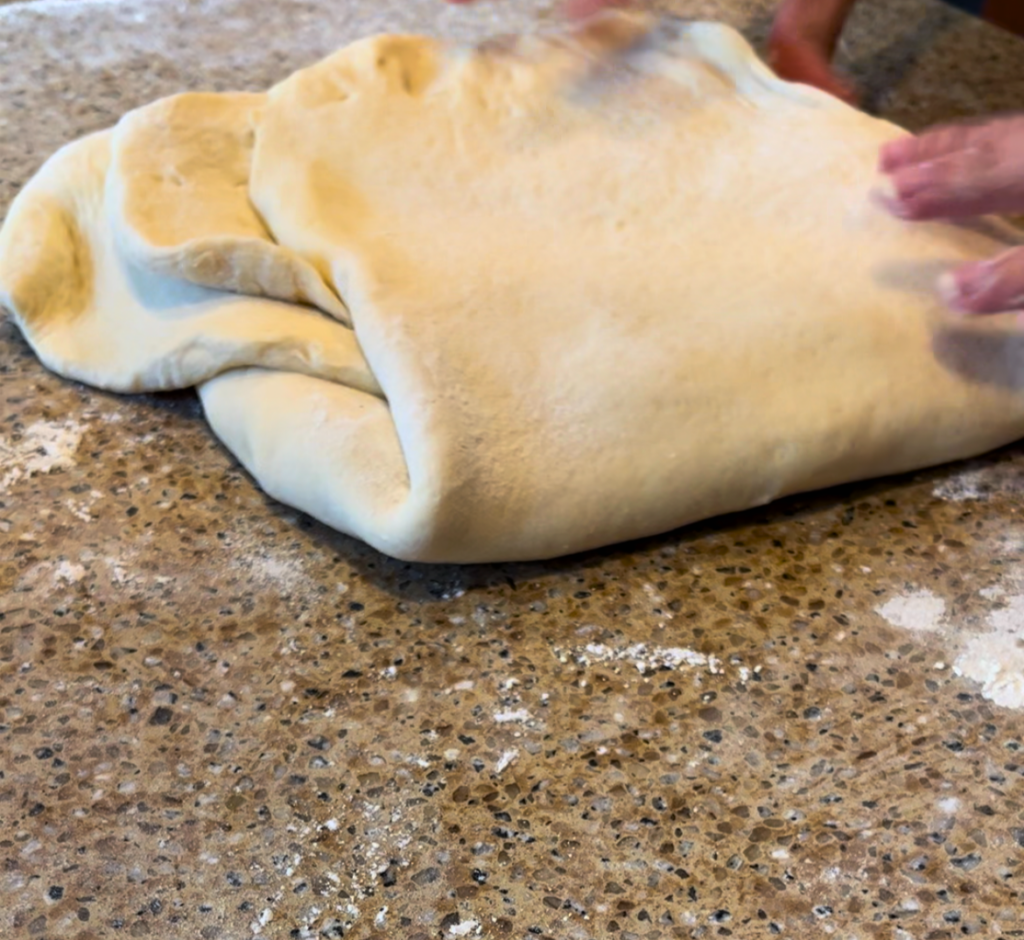 croissant dough folded up on a brown countertop