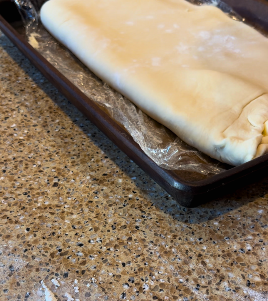 croissant dough on a cookie sheet on a brown counter