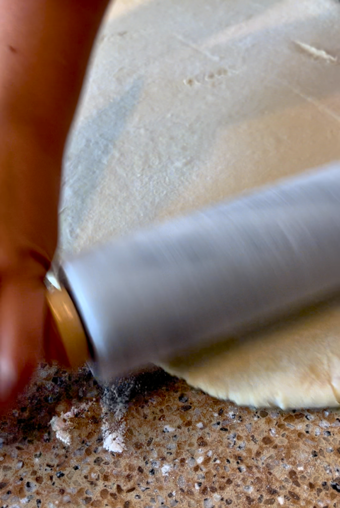 Woman rolling out croissant dough