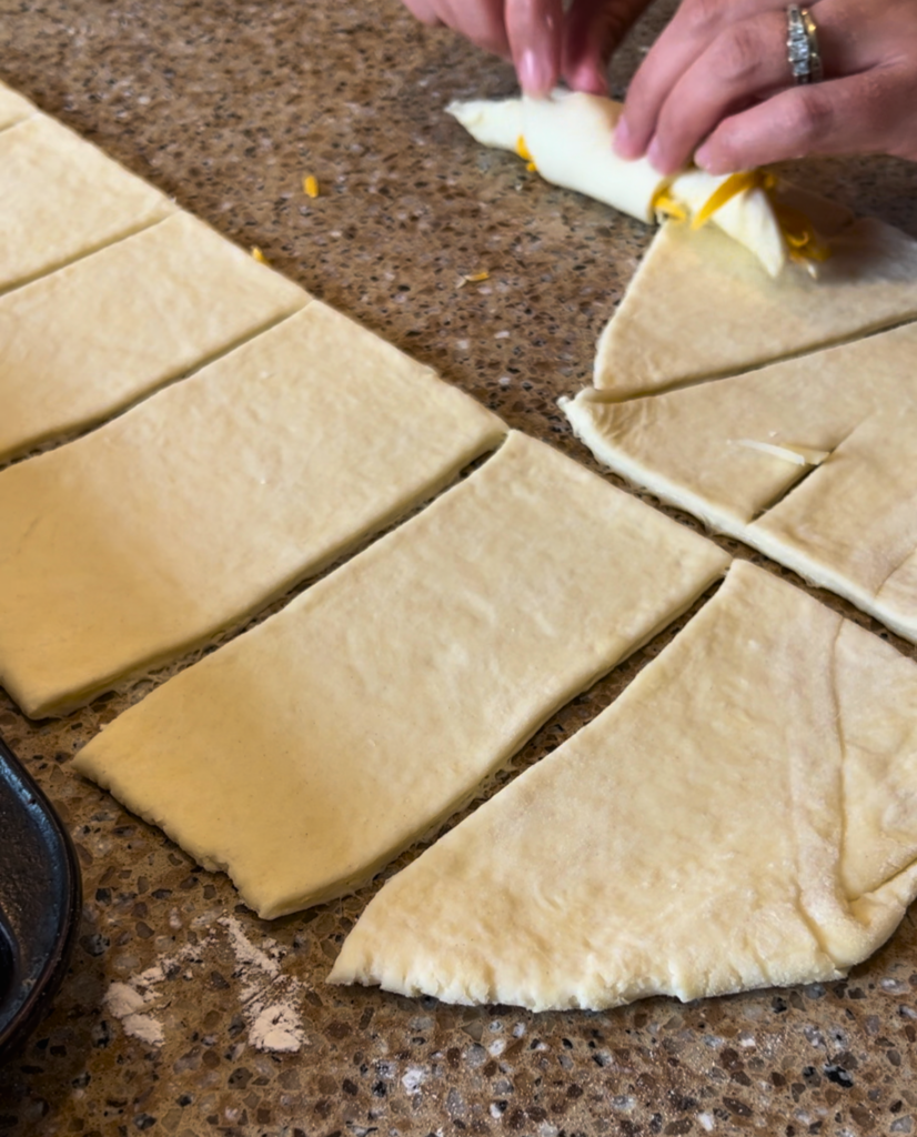 woman rolling cheese croissants