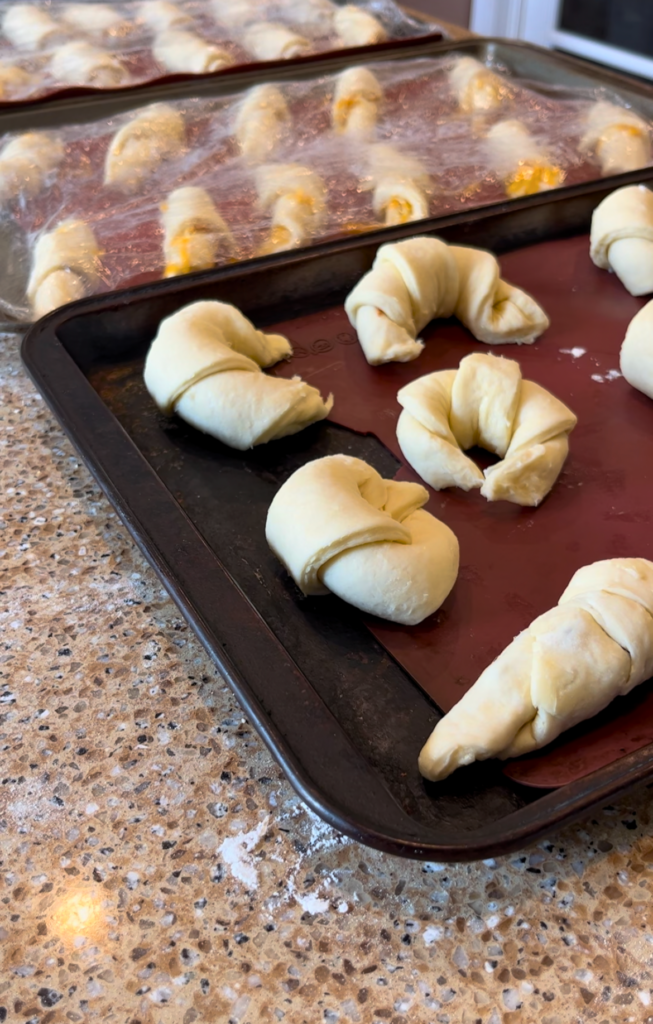 Croissants proofing on a cookie sheet