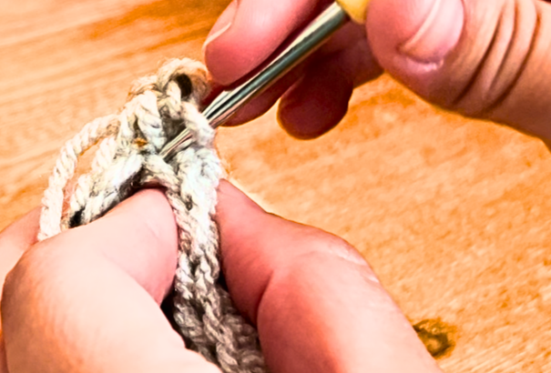 Woman joining the two ends of the fabric with a slip stitch