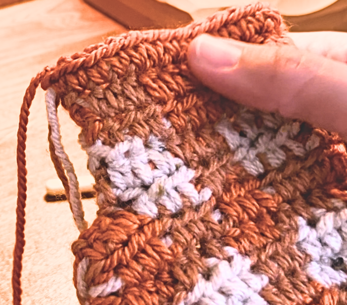 Woman finishing the crochet glove with a row of single crochet