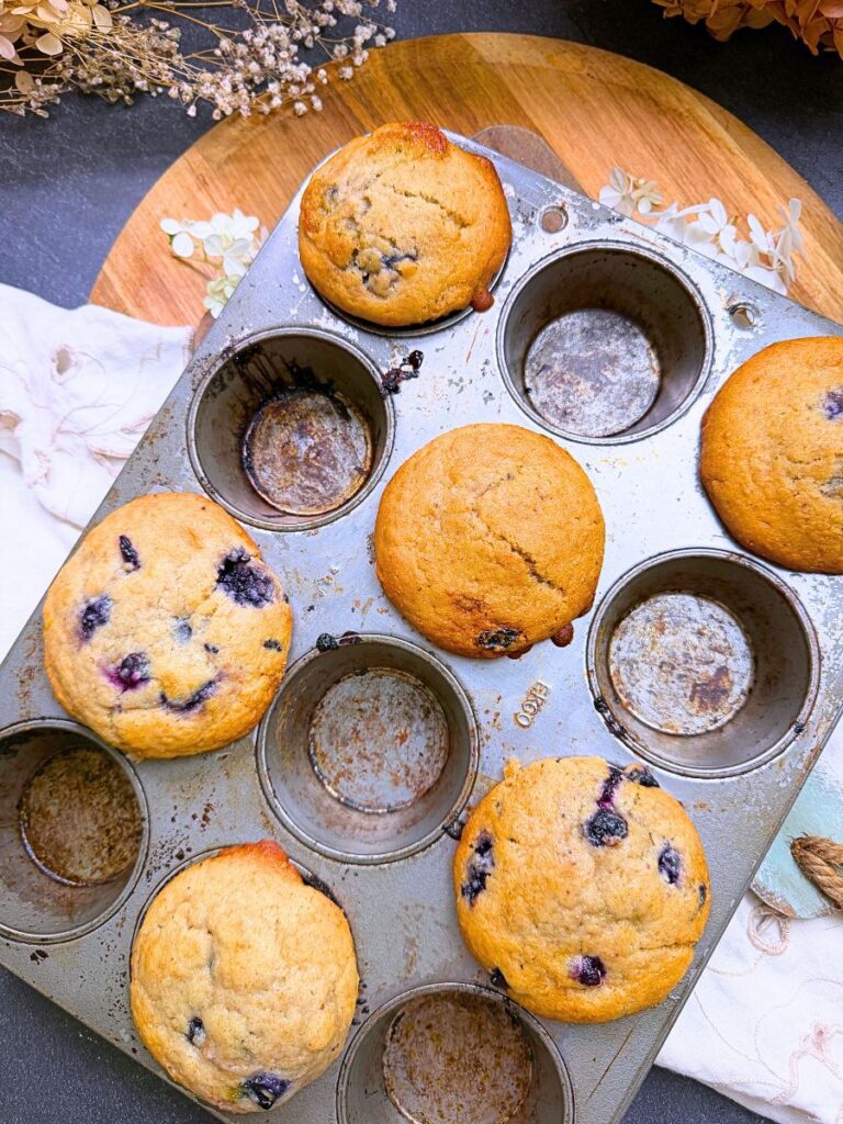 Baked lemon blueberry muffins in a muffin tin.