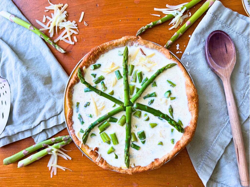 An unbaked asparagus and Swiss cheese quiche.