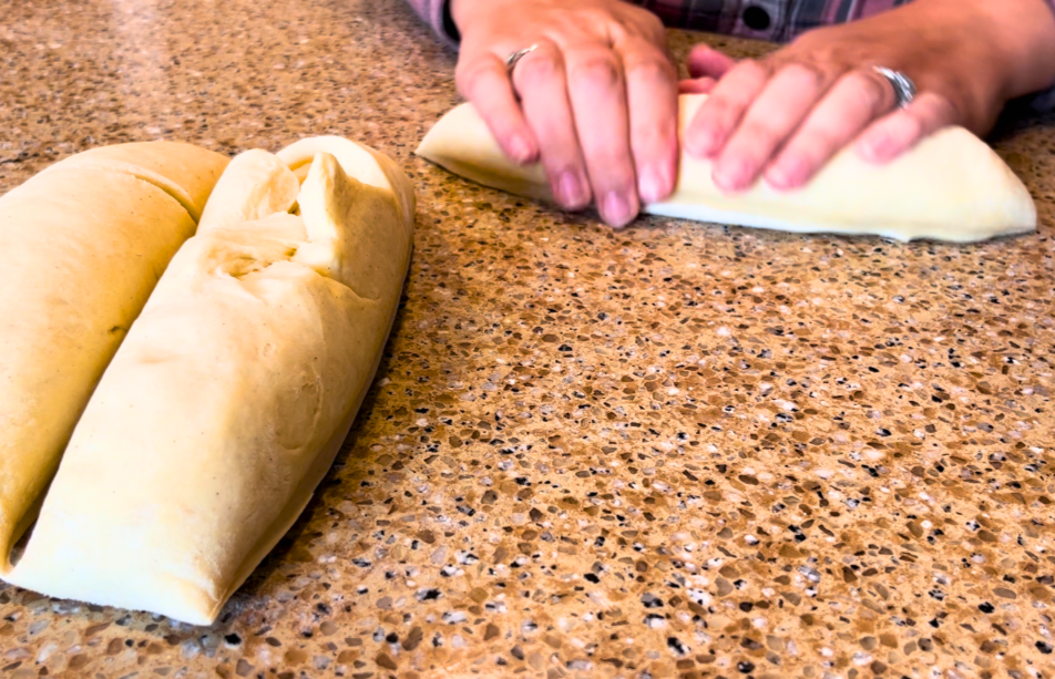 Woman splitting bread dough into 3 