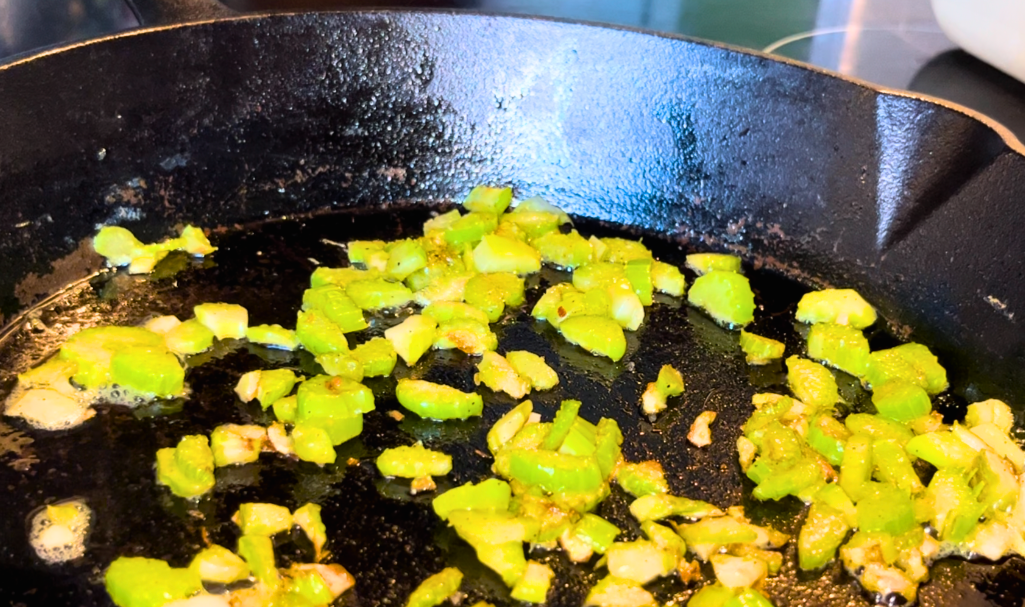 Celery cooking in a cast iron skillet