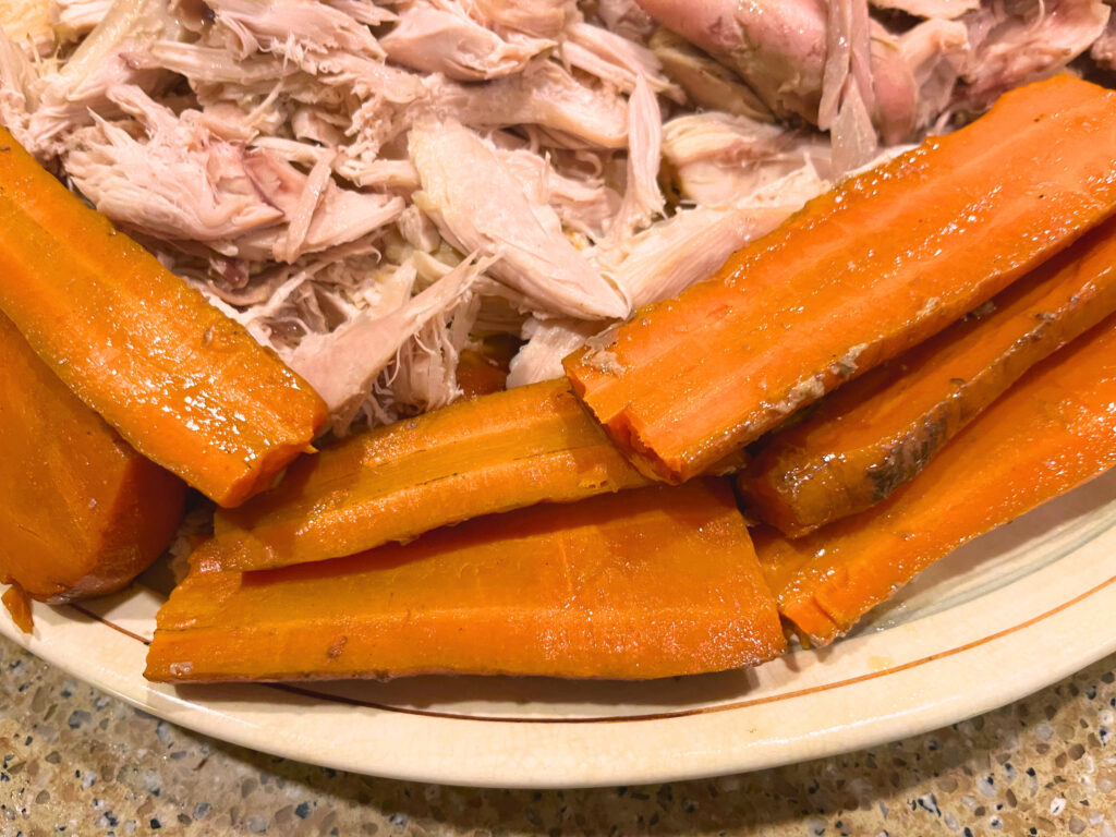 A platter with turkey meat and cooked carrots