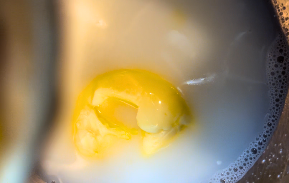 Butter melting in a metal bowl of warm milk