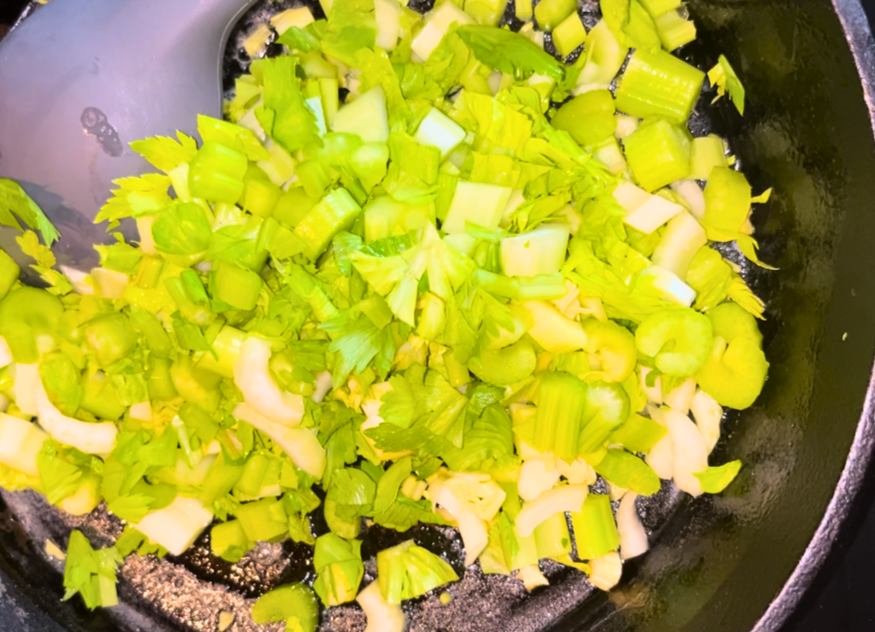 Chopped celery and onion in a frying pan with butter.