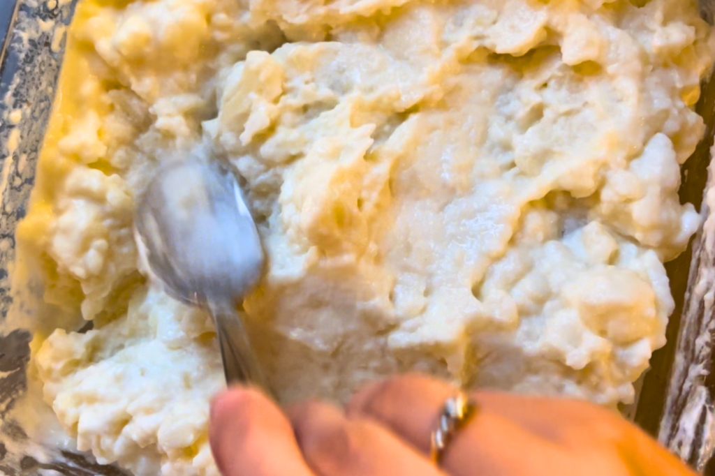 Smoothing out the mashed potato casserole with a spoon