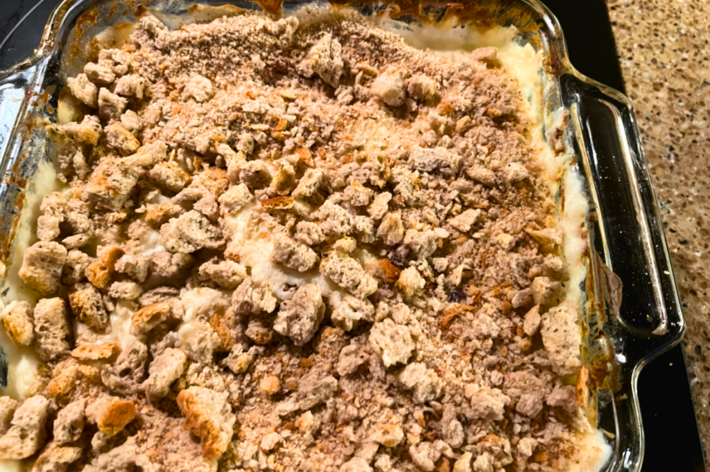 Bread crumbs on top of a mashed potato casserole in a square, glass casserole dish.