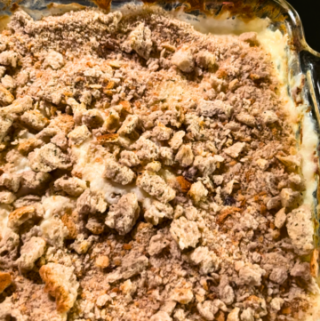 Bread crumbs on top of a mashed potato casserole in a square, glass casserole dish.