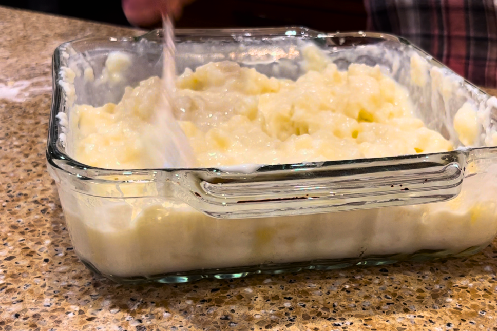 Mixing milk into the mashed potato casserole