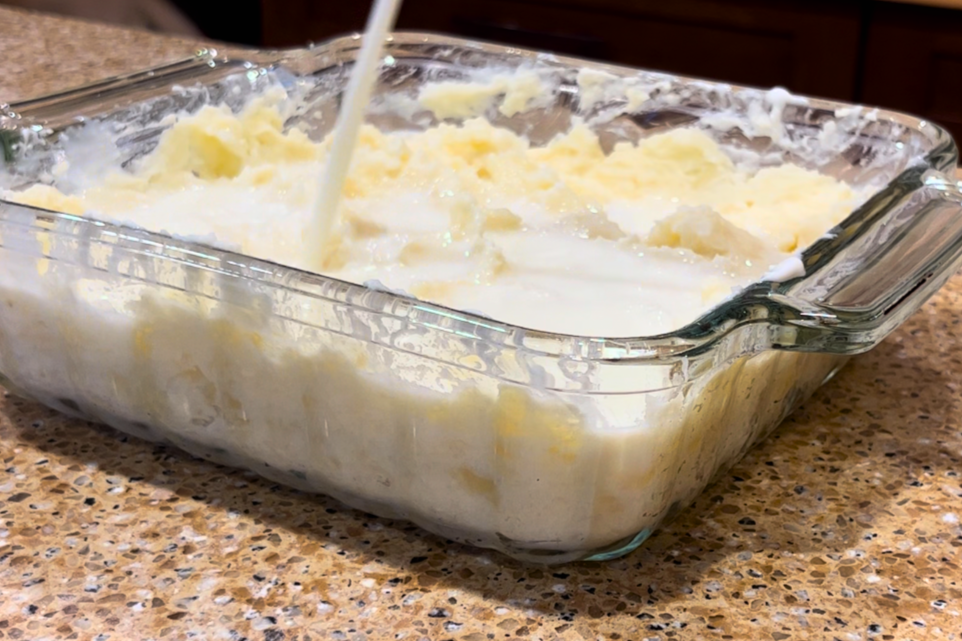 Mashed potatoes with milk being poured on top.