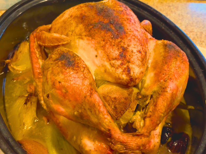 A roasted turkey in a roasting pan