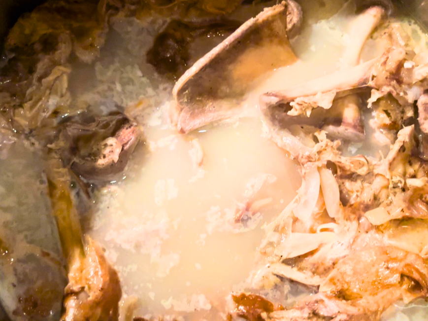 Turkey carcass simmering in a stockpot