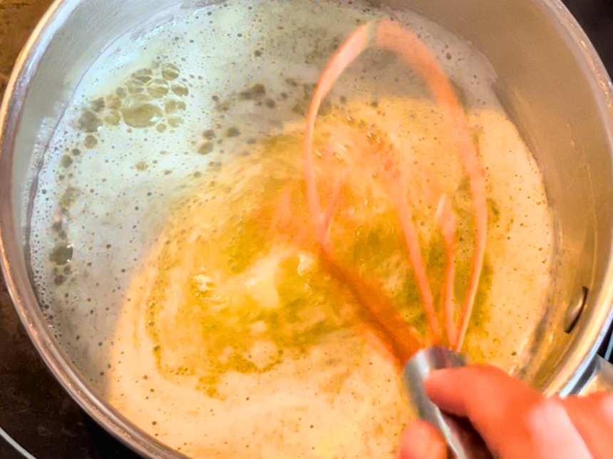 butter melting in a sauce pot. A whist mixing the butter