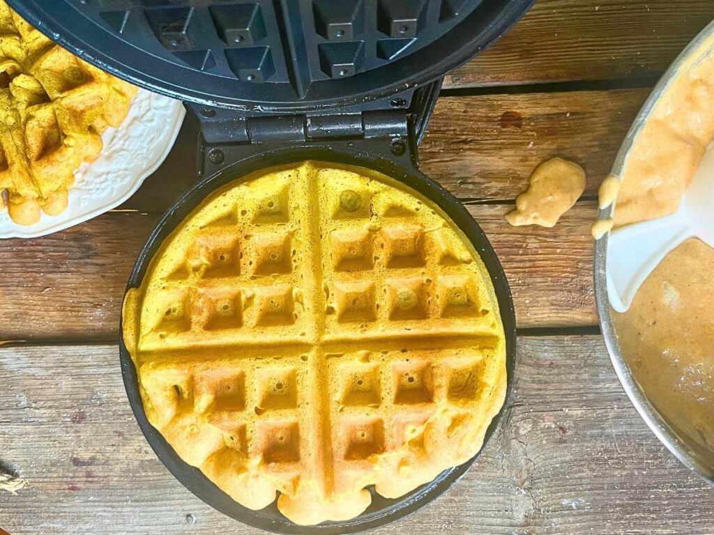 A waffle iron with a cooked waffle inside.