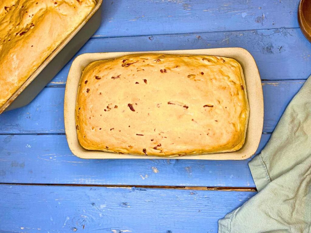 A baked cheese bread in a stone loaf pan.