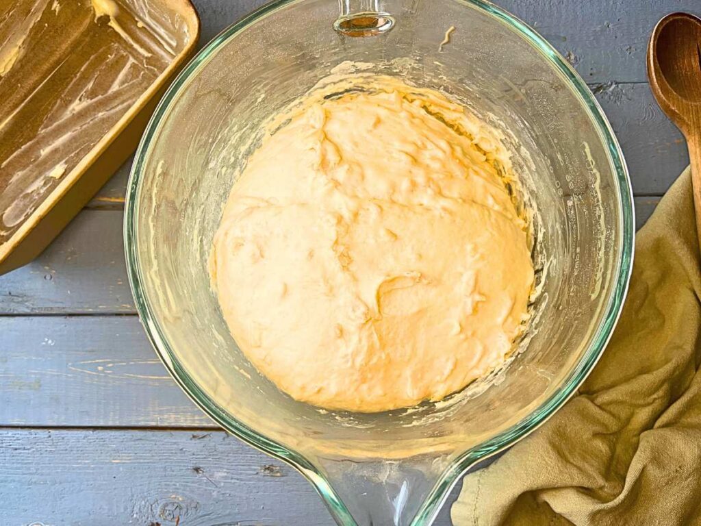 Cheese bread dough inside of a glass bowl.