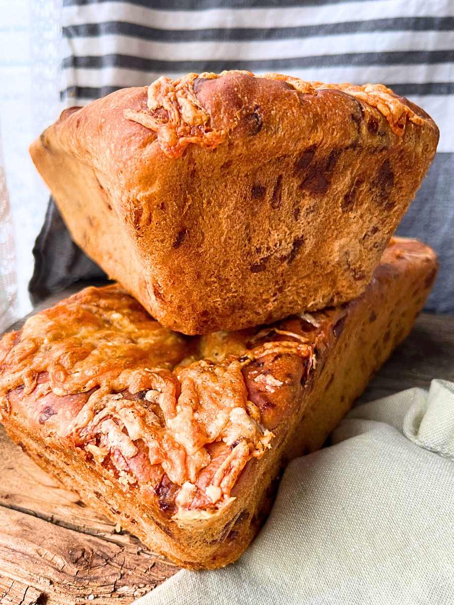 Two loaves of cheese bread stacked together.